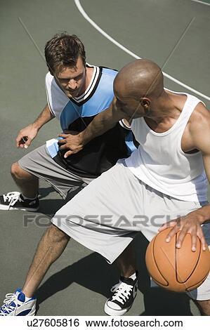 Two men playing basketball on a green urban outside court View Large Photo Image Stock Photograph - Two men playing basketball on a green urban outside court. Fotosearch