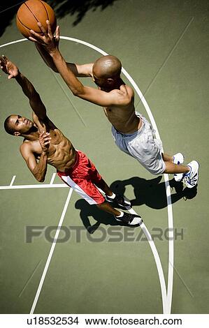 Picture - Two men playing on an outdoor basketball court . Fotosearch