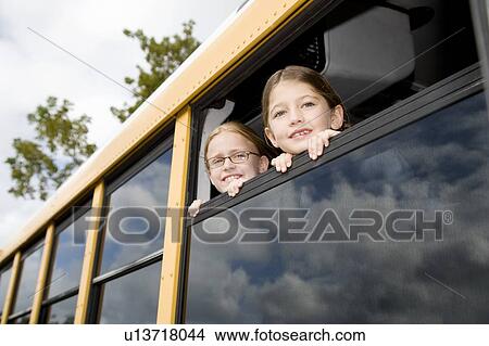 Picture - Two school girls on a school bus. Fotosearch