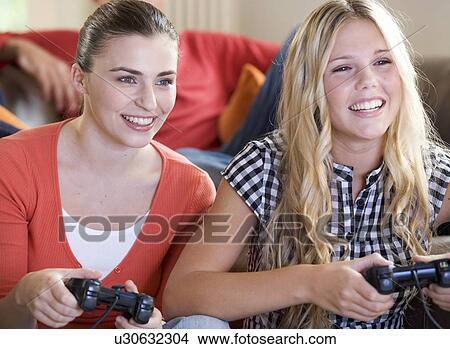 Two teenage girls playing a computer game View Large Photo Image Picture - Two teenage girls playing a computer game. Fotosearch