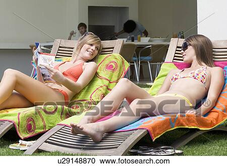 Two teenage girls sunbathing View Large Photo Image Stock Image - Two teenage girls sunbathing. Fotosearch