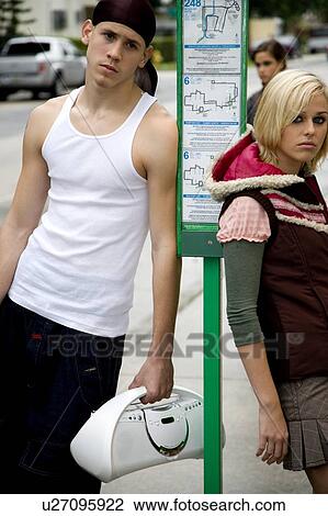 Two teenagers standing at a bus stop View Large Photo Image Stock Image - Two teenagers standing at a bus stop. Fotosearch