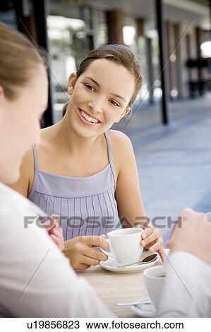 Two women drinking coffee at a pavement cafe View Large Photo Image Stock Image - Two women drinking coffee at a pavement cafe. Fotosearch
