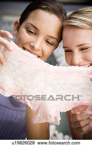 Two women sitting outside laughing at sexy underwear they've just purchased View Large Photo Image Stock Photo - Two women sitting outside laughing at sexy underwear they've just purchased. Fotosearch
