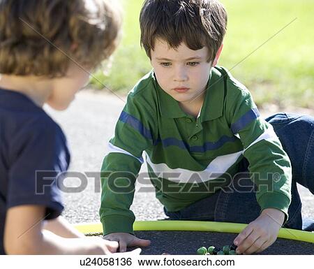 Two young boys playing marbles View Large Photo Image Stock Photograph - Two young boys playing marbles. Fotosearch