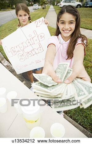 Stock Image - Two young girls at a lemonade stand. Fotosearch