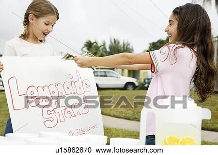 Stock Image - Two young girls at a lemonade stand. Fotosearch