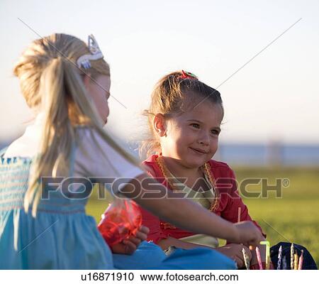 Stock Image - Two young girls on a birthday picnic. Fotosearch