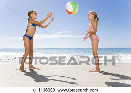 Stock Image - Two young girls playing on the beach. Fotosearch