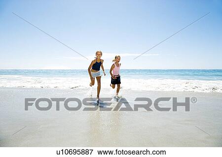 Two young girls running on the beach View Large Photo Image Stock Photo - Two young girls running on the beach. Fotosearch