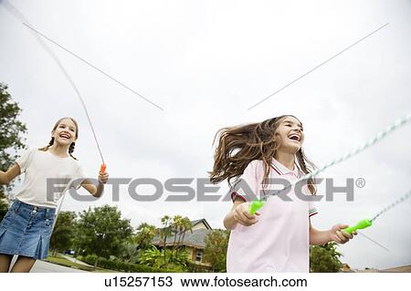 Stock Image - Two young girls skipping. Fotosearch