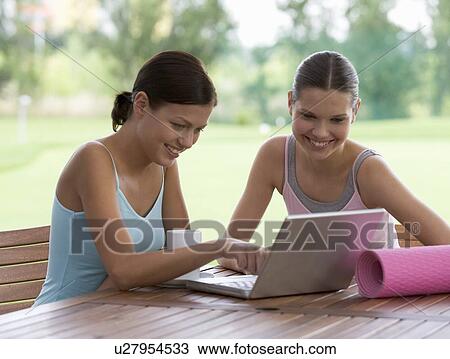 Two young with a laptop after a yoga class View Large Photo Image Stock Image - Two young with a laptop after a yoga class. Fotosearch