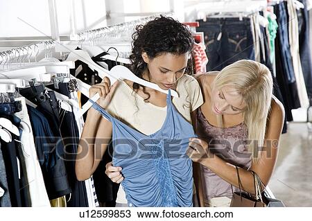 Two young women shopping for clothes View Large Photo Image Stock Image - Two young women shopping for clothes. Fotosearch