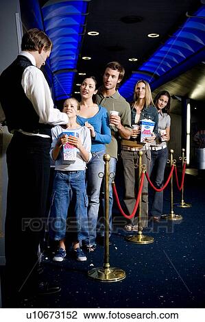 Usher with queue of people at the cinema View Large Photo Image Stock Image - Usher with queue of people at the cinema. Fotosearch