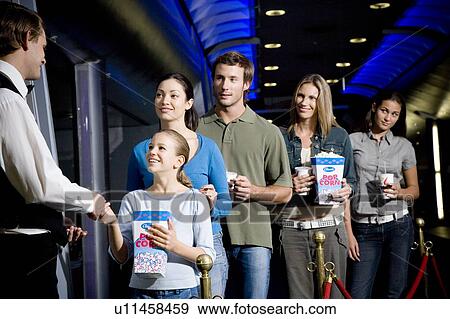 Usher with queue of people at the cinema View Large Photo Image Stock Photo - Usher with queue of people at the cinema. Fotosearch