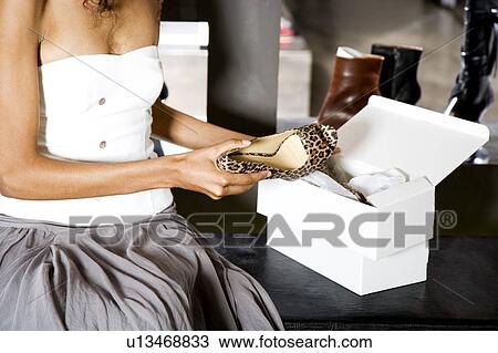 Woman buying high-heeled shoes in a shoe shop View Large Photo Image Stock Image - Woman buying high-heeled shoes in a shoe shop. Fotosearch