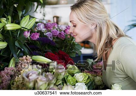 Stock Image - Woman choosing flowers in a florist's shop. Fotosearch