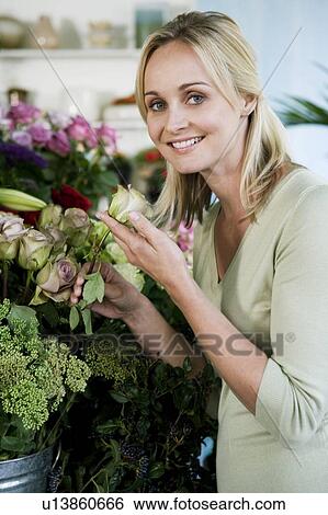 Stock Photograph - Woman choosing flowers in a florist's shop. Fotosearch