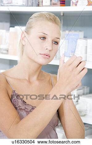 Woman choosing moisturising cream at the cosmetics counter View Large Photo Image Picture - Woman choosing moisturising cream at the cosmetics counter. Fotosearch