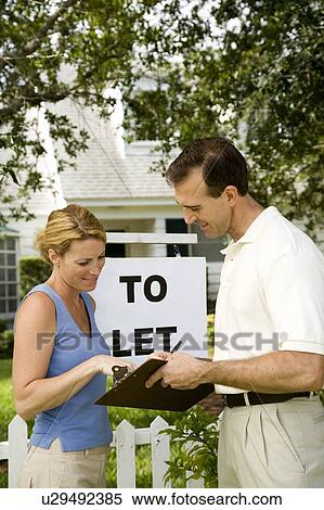 Stock Photography - Woman consulting letting agent about property to let. Fotosearch