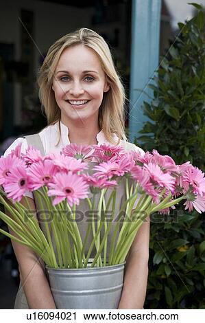Woman florist or gardener holding a large pot of pink asters View Large Photo Image Stock Image - Woman florist or gardener holding a large pot of pink asters. Fotosearch