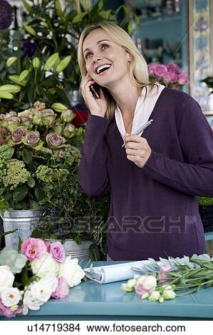 Woman florist taking an order over the telephone View Large Photo Image Picture - Woman florist taking an order over the telephone. Fotosearch