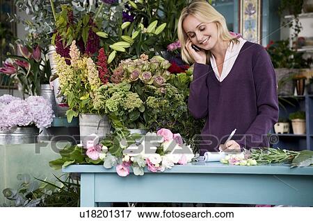 Woman florist taking an order over the telephone View Large Photo Image Stock Photo - Woman florist taking an order over the telephone. Fotosearch