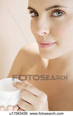Woman holding a pot of moisturising cream View Large Photo Image Stock Photograph - Woman holding a pot of moisturising cream. Fotosearch