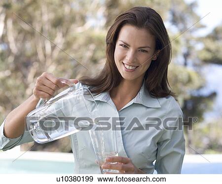 Stock Photo - Woman pouring a glass of water. Fotosearch