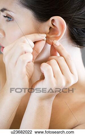 Woman putting in earrings View Large Photo Image Stock Image - Woman putting in earrings. Fotosearch