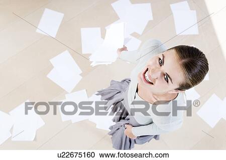 Woman smiling with dropped paperwork on the floor, aerial shot View Large Photo Image Stock Image - Woman smiling with dropped paperwork on the floor, aerial shot. Fotosearch