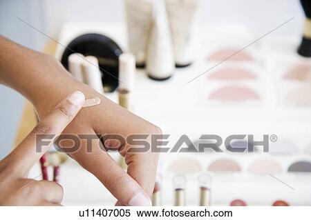 Woman testing foundation cream on her hand at the cosmetics counter View Large Photo Image Stock Photography - Woman testing foundation cream on her hand at the cosmetics counter. Fotosearch