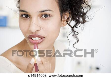 Woman trying on lipstick View Large Photo Image Stock Photo - Woman trying on lipstick. Fotosearch