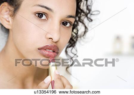 Woman trying on lipstick View Large Photo Image Stock Photograph - Woman trying on lipstick. Fotosearch