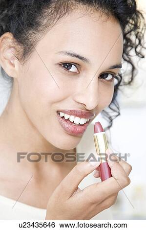 Woman trying on lipstick View Large Photo Image Stock Photograph - Woman trying on lipstick. Fotosearch