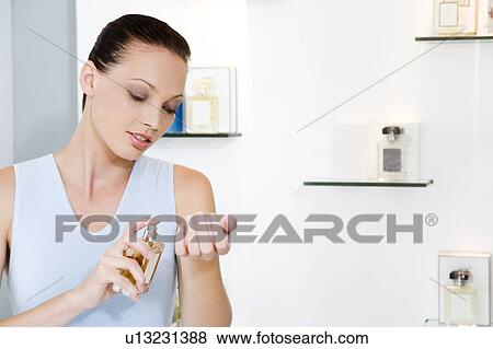 Woman trying on perfume in a store View Large Photo Image Stock Photo - Woman trying on perfume in a store. Fotosearch