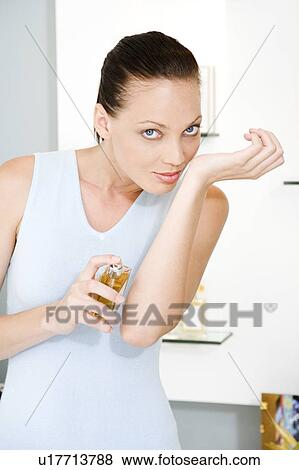 Woman trying on perfume in a store View Large Photo Image Stock Photo - Woman trying on perfume in a store. Fotosearch