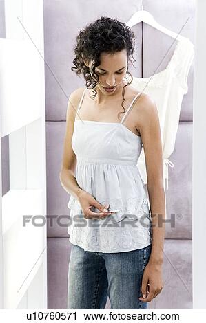 Woman trying on sun tops in the changing room of a shop, checking the price View Large Photo Image Stock Image - Woman trying on sun tops in the changing room of a shop, checking the price. Fotosearch