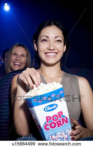 Stock Photo - Woman watching a humorous film at the cinema. Fotosearch