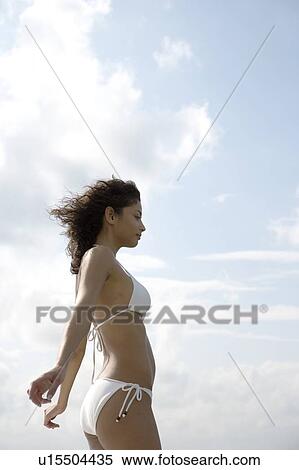 Stock Photography - Woman with arms outstretched against a summer sky. Fotosearch
