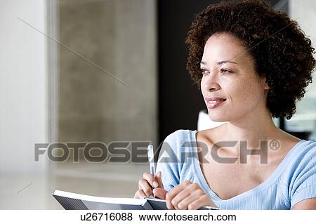 Stock Photo - Woman writing a diary or journal at home. Fotosearch