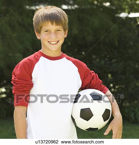 Young boy holding a football View Large Photo Image Stock Image - Young boy holding a football. Fotosearch