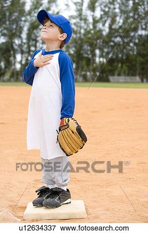Young boy on baseball base praying View Large Photo Image Stock Photo - Young boy on baseball base praying. Fotosearch
