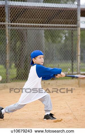 Stock Image - Young boy swinging baseball bat. Fotosearch