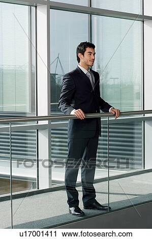 Stock Image - Young businessman in smart, modern office. Fotosearch