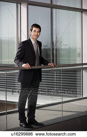 Young businessman in smart, modern office View Large Photo Image Stock Photograph - Young businessman in smart, modern office. Fotosearch