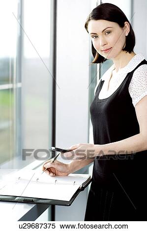 Young businesswoman or secretary making an appointment in a diary View Large Photo Image Stock Photography - Young businesswoman or secretary making an appointment in a diary. Fotosearch