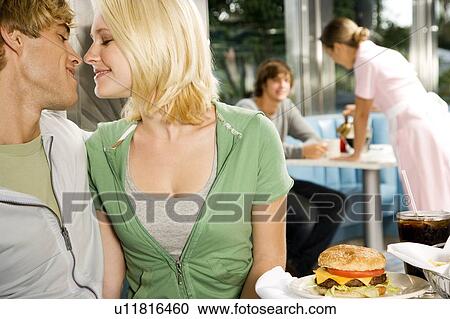 Young couple about to kiss, sitting in a diner View Large Photo Image Stock Image - Young couple about to kiss, sitting in a diner . Fotosearch