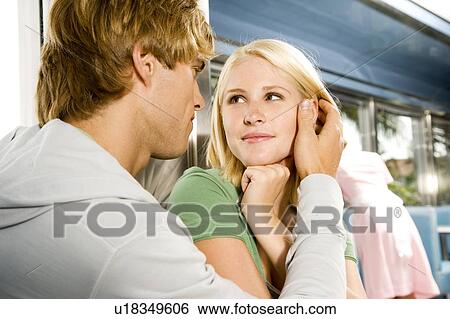 Stock Photograph - Young couple about to kiss, sitting in a diner . Fotosearch