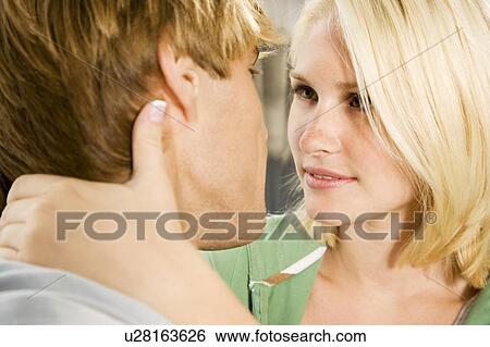 Stock Photograph - Young couple about to kiss,. Fotosearch